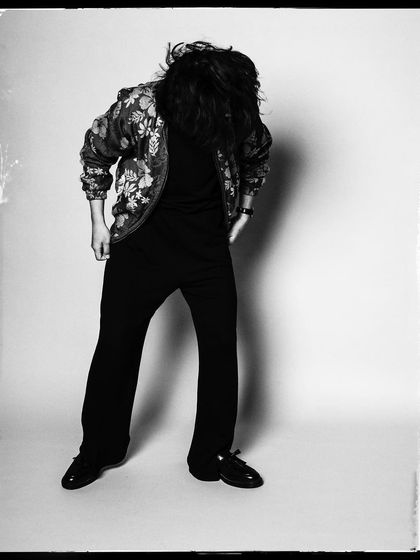 A dynamic black and white shot of Taba Chake, with his hair in motion. It captures his energy and the feeling of being lost in the music.