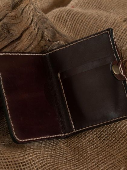The inside of a handmade bifold leather wallet, showing the card slots and clean stitching. Participants learn to design and construct practical items like this from start to finish.