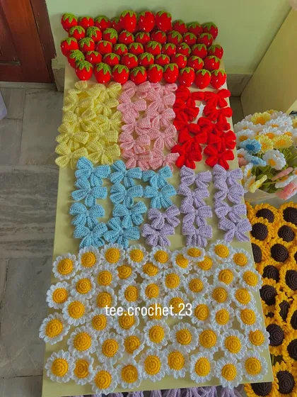 A colorful flat lay of various keychain designs. This order included strawberry, multi-colored bows, and daisy keychains, showing the customization options available.