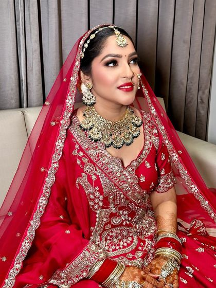 A profile shot highlighting the contouring and the intricate details of her bridal jewelry and makeup.