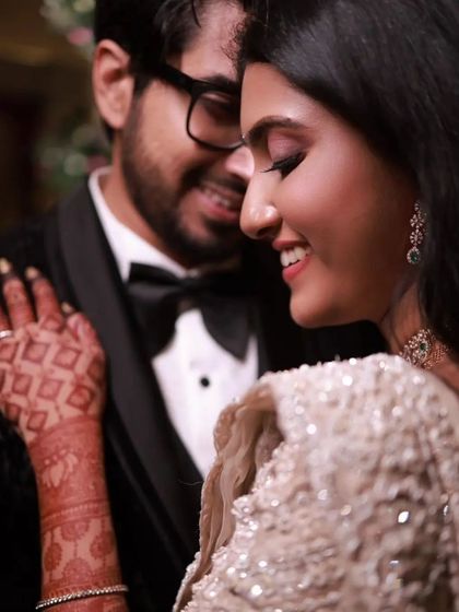 A romantic close-up of a couple, where the bride's beautifully stained hand is a gentle focal point. The design's rich color enhances the elegance of the moment.