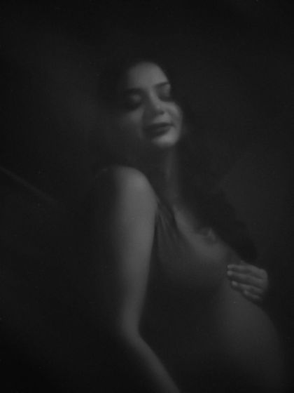 A mysterious and beautiful black and white portrait. The soft focus and deep shadows create an intimate and artistic mood.