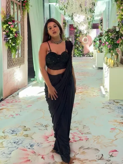 The full look. A modern black saree for a beautifully decorated event.