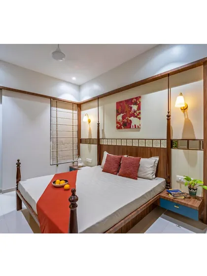 A full view of the traditional Indian-style bedroom, showing the four-poster bed, side tables, and wardrobe. The design is a perfect fusion of style and solace.