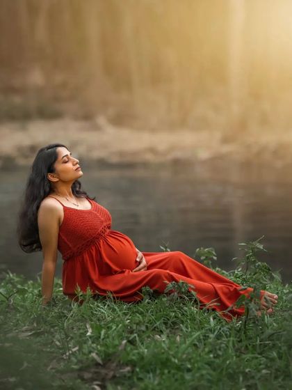 A duplicate of ID 23, this serene outdoor portrait captures an expecting mother relaxing in the grass by the water, basking in the warm sunlight and enjoying a moment of peace.