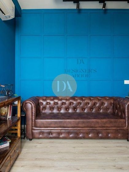 A shot of the bold blue study and lounge area from our featured Gurgaon project. The tan leatherette sofa and wooden bookshelf create a warm and inviting contrast against the vibrant wall.