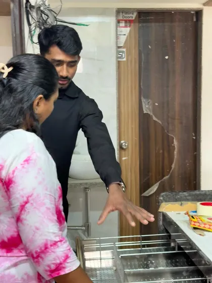 On-site with a client, explaining the mechanism of a modular kitchen drawer system during the installation phase.