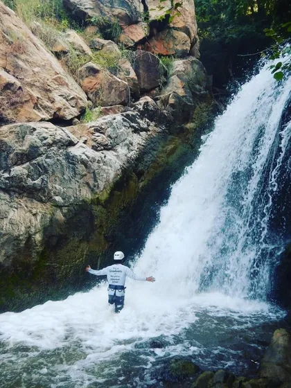 That feeling when you conquer the waterfall. This is a graduate at City Falls, Kolar, embracing the flow after a successful rappel. This is the confidence we build.