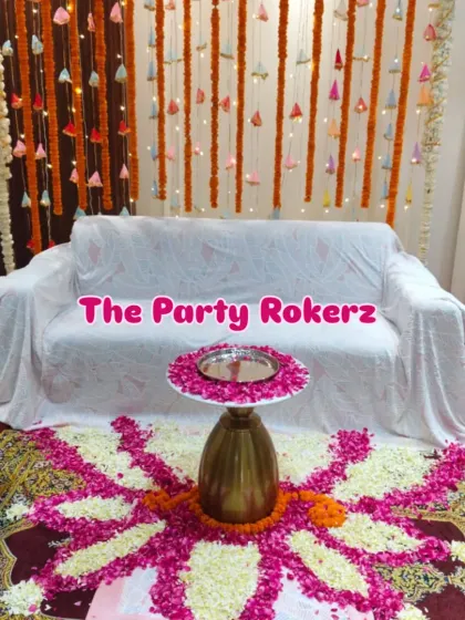 A beautiful flower rangoli made with rose and jasmine petals, placed in front of the seating area for a home kirtan.