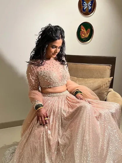 For a Sangeet or Reception, we can create a stunning glam look. This style features soft, flowing curls and dramatic eyes, perfect for an evening of celebration and dancing.