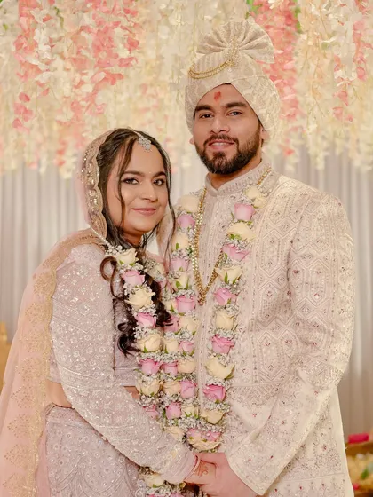 The couple at their ceremony. Madhura's baby pink lehenga and elegant makeup make for a stunning and modern bridal look.