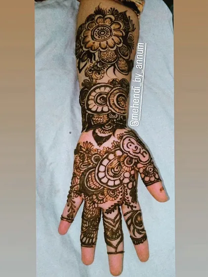 This intricate design is a beautiful fusion of styles, with paisley elements, detailed finger work, and a bold floral cuff.