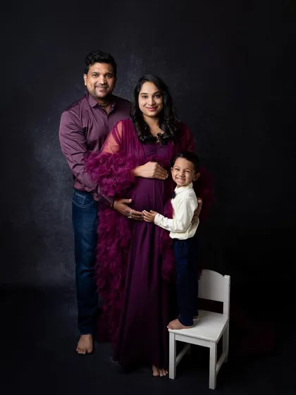 A complete family portrait during a maternity session. The older brother joins his parents, creating a beautiful image of the family as they wait to welcome their newest member.