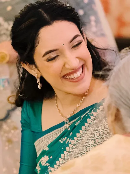 A joyful, candid moment from the engagement ceremony. Shalmali's natural glam makeup looks stunning as she shares a laugh with her family.