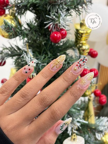 A beautiful shot of the intricate Christmas party nails in front of a decorated tree, highlighting the festive details.