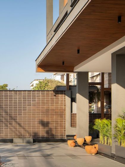 The 8-hole brick boundary wall, with its textured elegance, offers a cost-effective yet striking introduction to the home. The play of light and shadow on the bricks changes throughout the day.