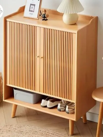 A light wood shoe cabinet with vertical slats, perfect for a Scandinavian or minimalist interior.