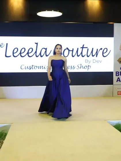 A model showcasing my royal blue strapless ball gown on the stage at the Celebrity Business Awards. The simple, elegant design allows the rich color and fabric to take center stage.