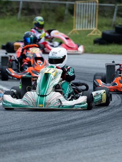 A competitor leads a pack of karts during an international race, showing the high level of competition.