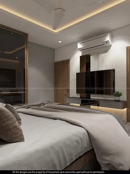 The TV unit in this master bedroom is sleek and unobtrusive, mounted on a marble-finish wall.