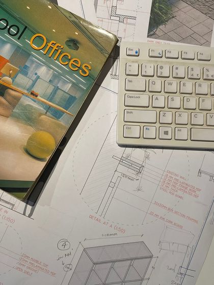 A flat lay of our work desk, covered in technical drawings, reference books, and a keyboard. This image captures the buzz of the studio as we craft spatial identities for brands across India and the UAE.