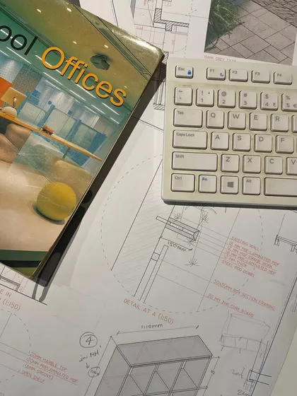 A flat lay of our work desk, covered in technical drawings, reference books, and a keyboard. This image captures the buzz of the studio as we craft spatial identities for brands across India and the UAE.
