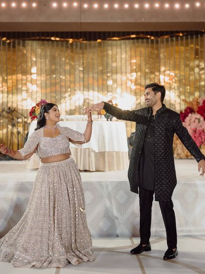 The couple's coordinated dance performance on their Sangeet night, set against a glittering gold backdrop.