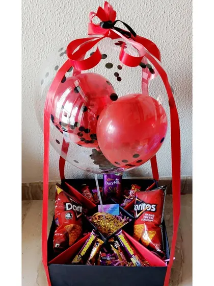 Bring on the fun with a vibrant birthday hamper. This creation features a black and red theme with festive balloons, and is packed with snacks like Doritos and a variety of chocolates, perfect for a cheerful birthday surprise.