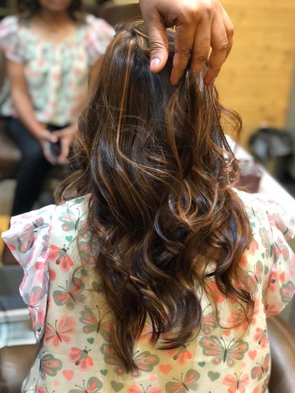 This image showcases a subtle balayage on medium-length hair. The lighter pieces are focused on the mid-lengths and ends, creating a natural, sun-touched appearance.