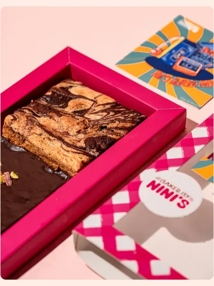 A detailed macro shot of a marbled brownie in its vibrant pink gift box. I focus on texture and detail to make the food look as delicious as it tastes.