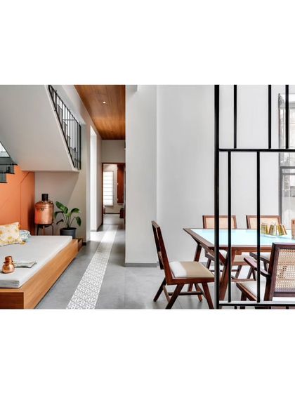 A view from the dining area into the living space, where a simple metal screen provides a sense of separation without blocking light or views.