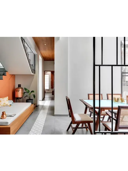 A view from the dining area into the living space, where a simple metal screen provides a sense of separation without blocking light or views.