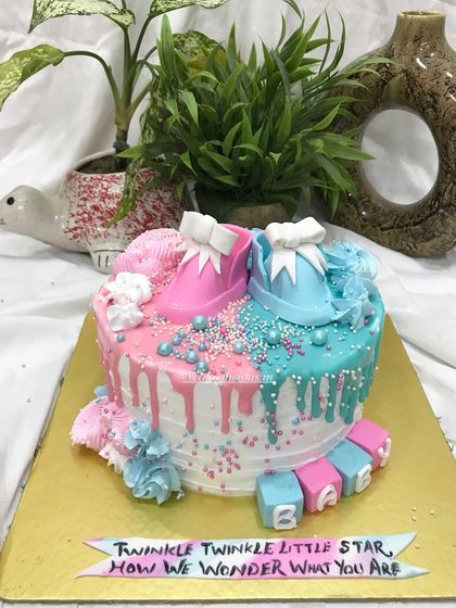 This view highlights the colorful sprinkles and drips on the gender reveal cake.