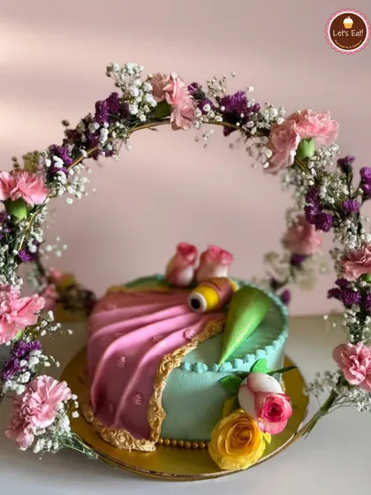 I designed this cake to look like an elegant saree, complete with a delicate floral arch. It was for a very special occasion, blending traditional art with modern baking. I used fresh cream and fondant to create the draping effect and intricate details.