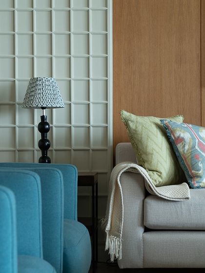 This shot highlights the interplay of textures and colors, with a bright blue armchair next to a neutral sofa. The space feels collected and personal, not overly designed.