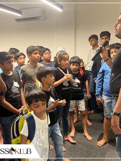 A coach briefing a group of eager young students before a tournament. We foster an interactive environment where kids feel comfortable asking questions and learning together.