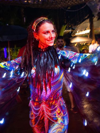 A close-up portrait of the artist in her colorful, light-up costume. This look is vibrant, unique, and full of positive energy.