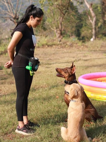 A candid shot from one of our doggy camps. Here I am in my element, working on focus and obedience with two dogs in a fun, outdoor setting.