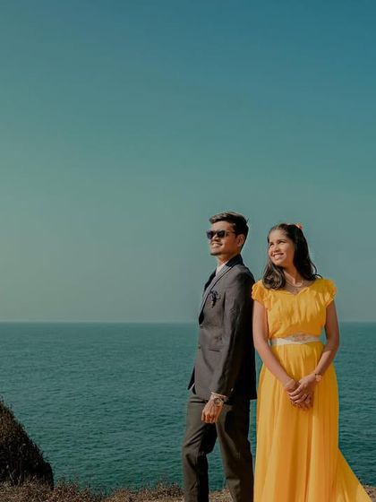 Back to back, looking towards a future together. This couple's beachside pre-wedding shoot is beautifully captured, featuring a sunny yellow gown.