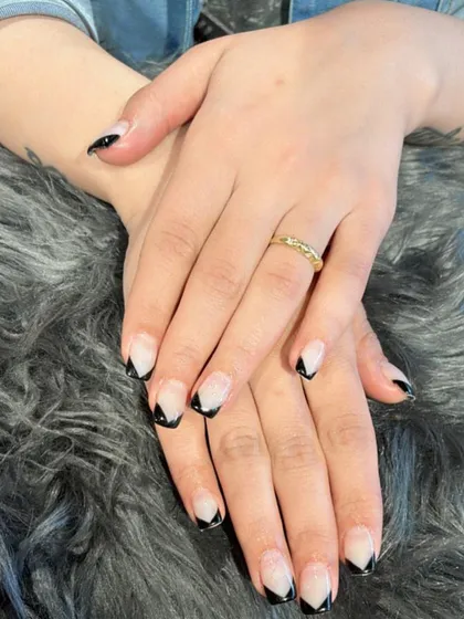 This V-shaped French tip in classic black offers a chic and edgy alternative to the traditional curved line. It's a great way to elongate the look of your nails.