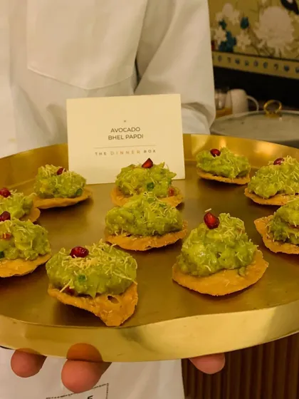 A server presents a tray of our popular Avocado Bhel Papdi canapés, a refreshing and modern twist on a classic Indian snack.