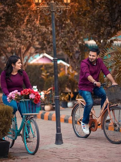 A cheerful shot of a couple riding our vintage bicycles along a paved path in the studio grounds. This setup is perfect for capturing fun and active pre-wedding moments.