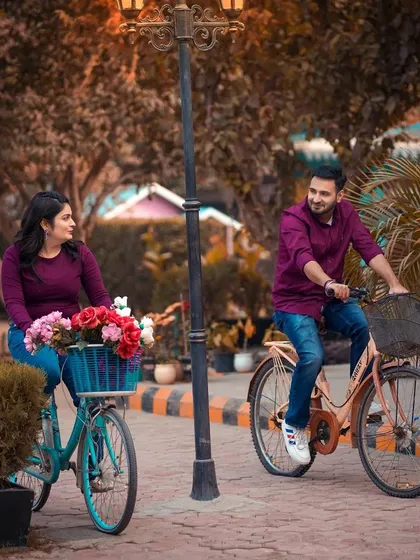 A cheerful shot of a couple riding our vintage bicycles along a paved path in the studio grounds. This setup is perfect for capturing fun and active pre-wedding moments.