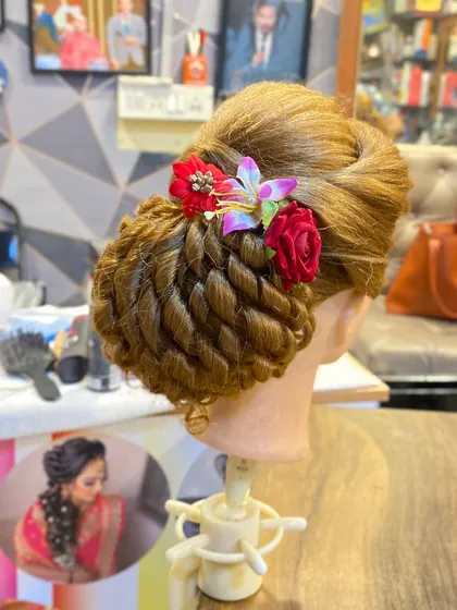 Another view of the twisted bun with floral accents. This is a great example of the beautiful work my students produce.