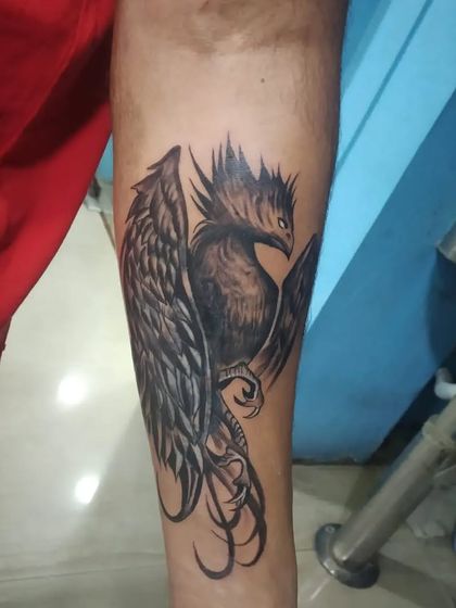 A phoenix tattoo on the forearm. This mythical bird, rising from the ashes, is a powerful symbol of rebirth, resilience, and starting anew.