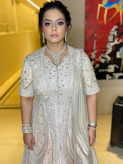 The complete look is nothing short of regal. Her makeup is polished and refined, designed to complement the intricate details of her outfit and jewelry.