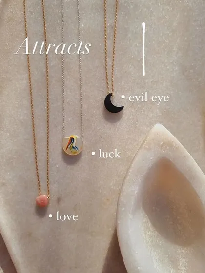 A look at some of my most popular pendants, each with a specific purpose. I use pink opal to attract love, hand-paint a stork on moonstone for luck, and carve black onyx to protect against the evil eye.