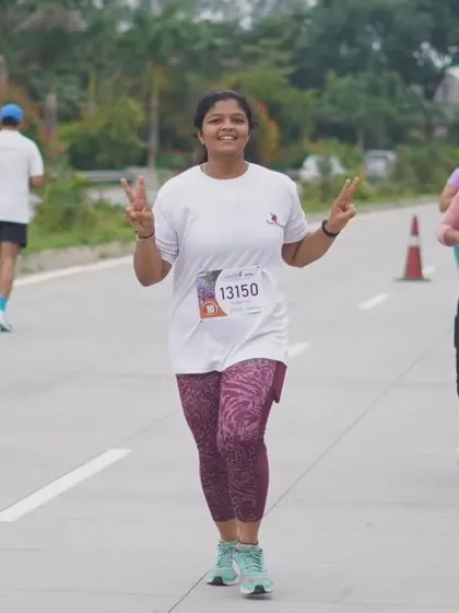 A runner flashing a peace sign during the Bengaluru 10K Challenge, feeling strong and positive on the course.