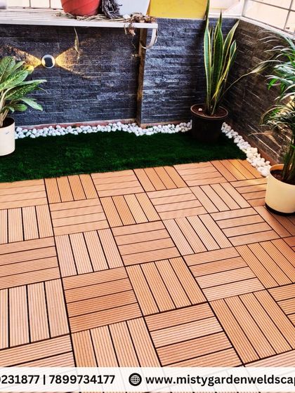 Artificial grass paired with WPC tiles creates a clean, modern, and maintenance free floor for this balcony. We added potted plants and white pebbles for a complete look.