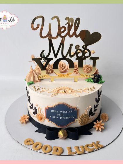 A sweet and stylish farewell cake. This design features a "We'll Miss You" topper and is decorated with delicate black and gold floral details.